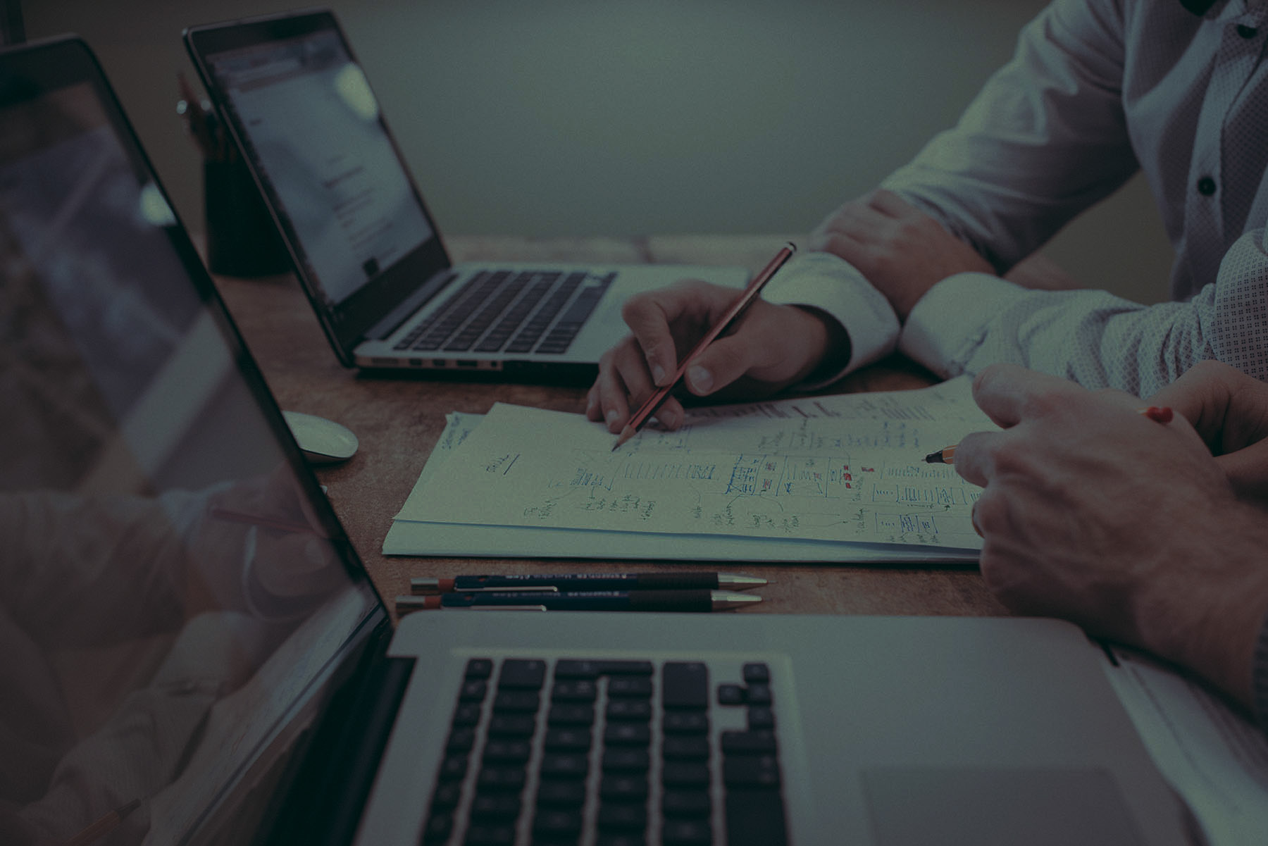header image showing workers collaborating at a desk